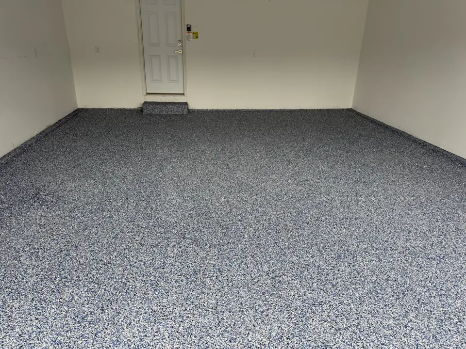 Finished basement room with a grey flake epoxy floor and freshly painted walls, ready for framing