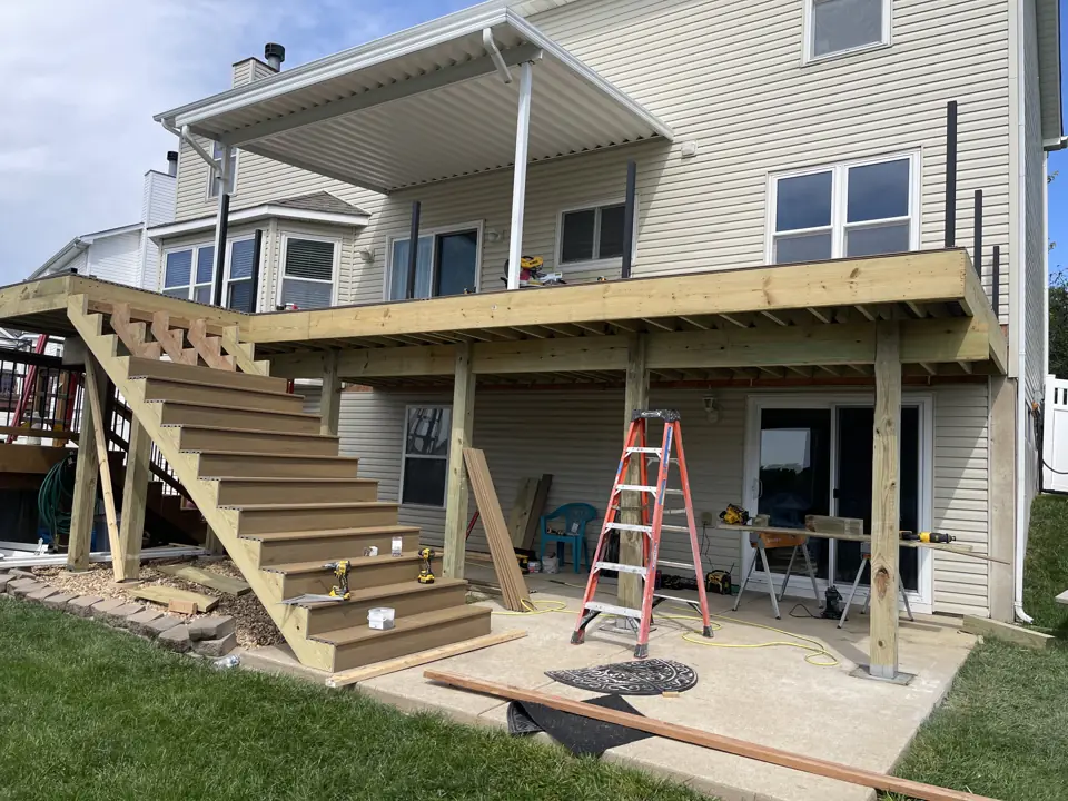 Second-story deck with a white aluminum roof cover and a full-width stair to the patio below