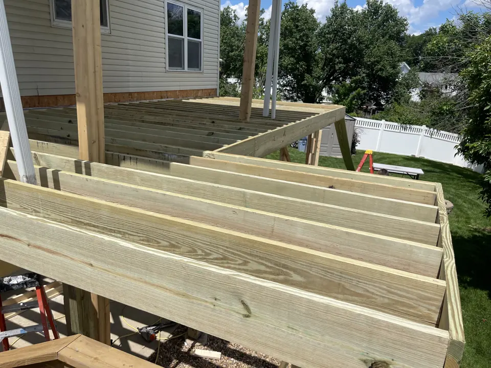 Pressure-treated deck joists and rim boards framed on posts, before the deck boards are installed